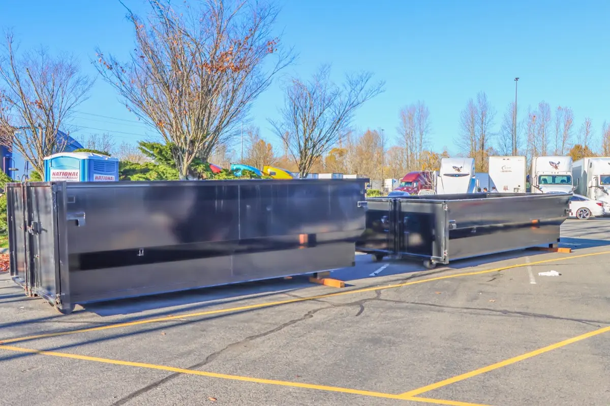 Professional dumpster rental service with roll-off container on residential driveway in Oak Point